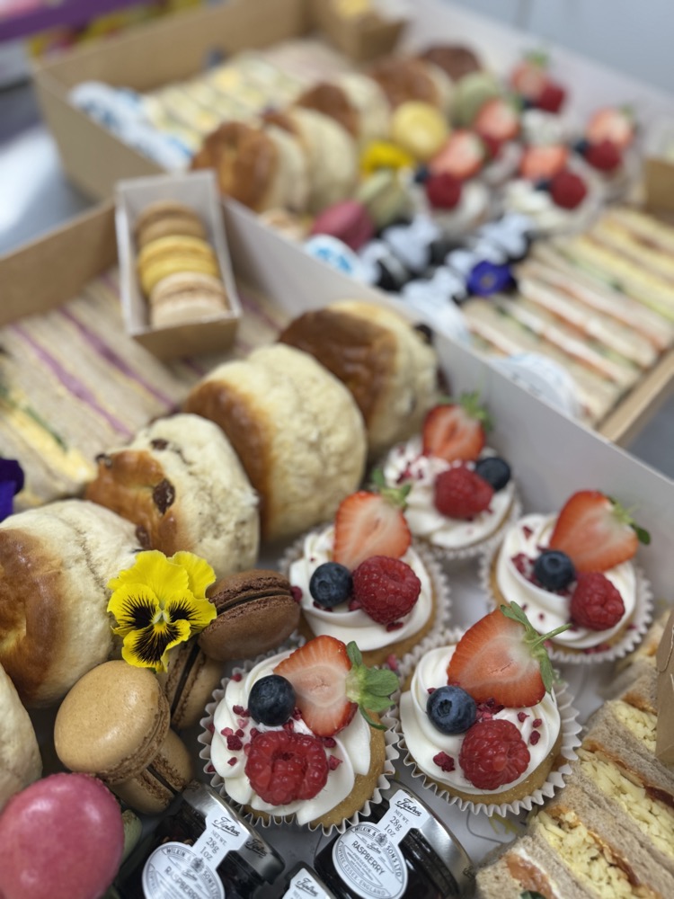 Brunch spread of sandwiches, granola pots, croissants and fresh fruit