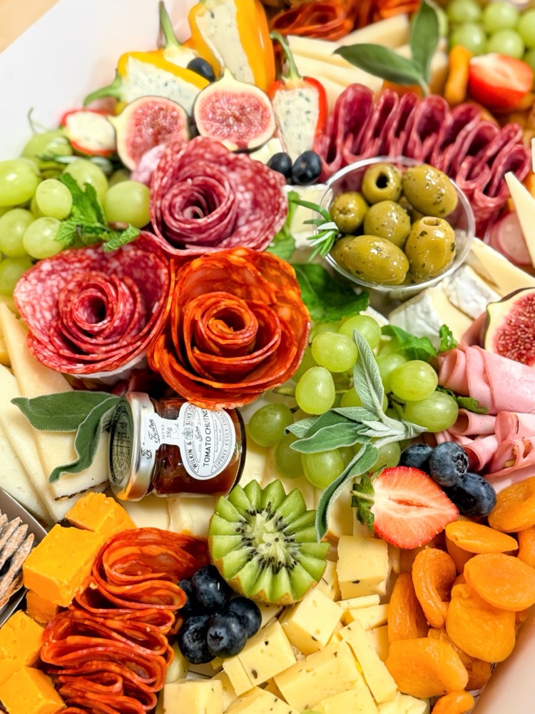Charcuterie board with salami roses, cheese, figs, olives and fresh berries