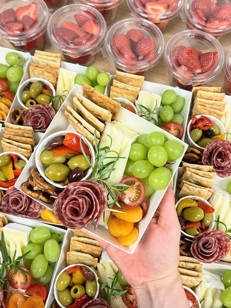 Grazing boxes with cheese, cured meat roses, olives, grapes and crackers