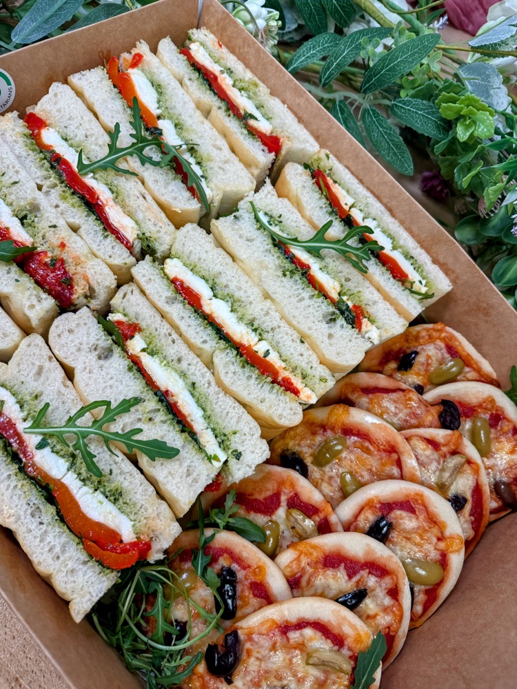 Boxes of sandwiches, wraps and fruit tartlets for a catering order