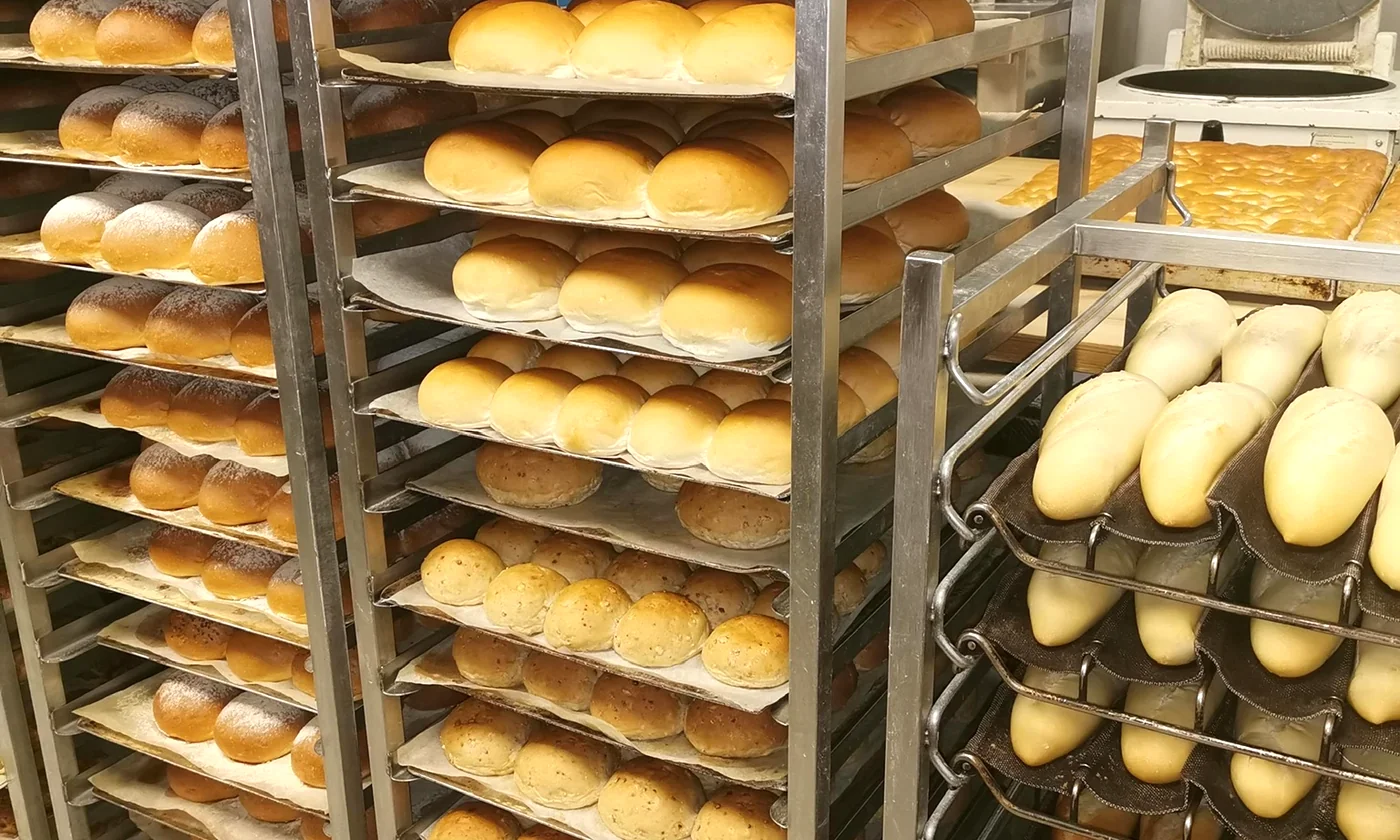 Racks of freshly baked loaves and rolls in the Happy Toast bakery
